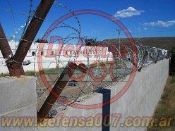 Instalación de concertina helicoidal cruzada de 70 cm sobre muro de bloques portantes. Zona Comodoro Rivadavia.
