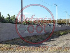 Vista panorámica. Instalación de concertina helicoidal cruzada de 70 cm sobre muro de bloques portantes. Zona Comodoro Rivadavia.
