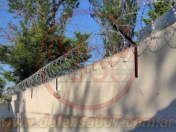 Instalación de concertina helicoidal cruzadade 45 cm sobre muro con soportes inclinados.