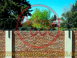 Instalación de concertina plana de 45 cm sobre muro pintada de verde. Zona La Horqueta.